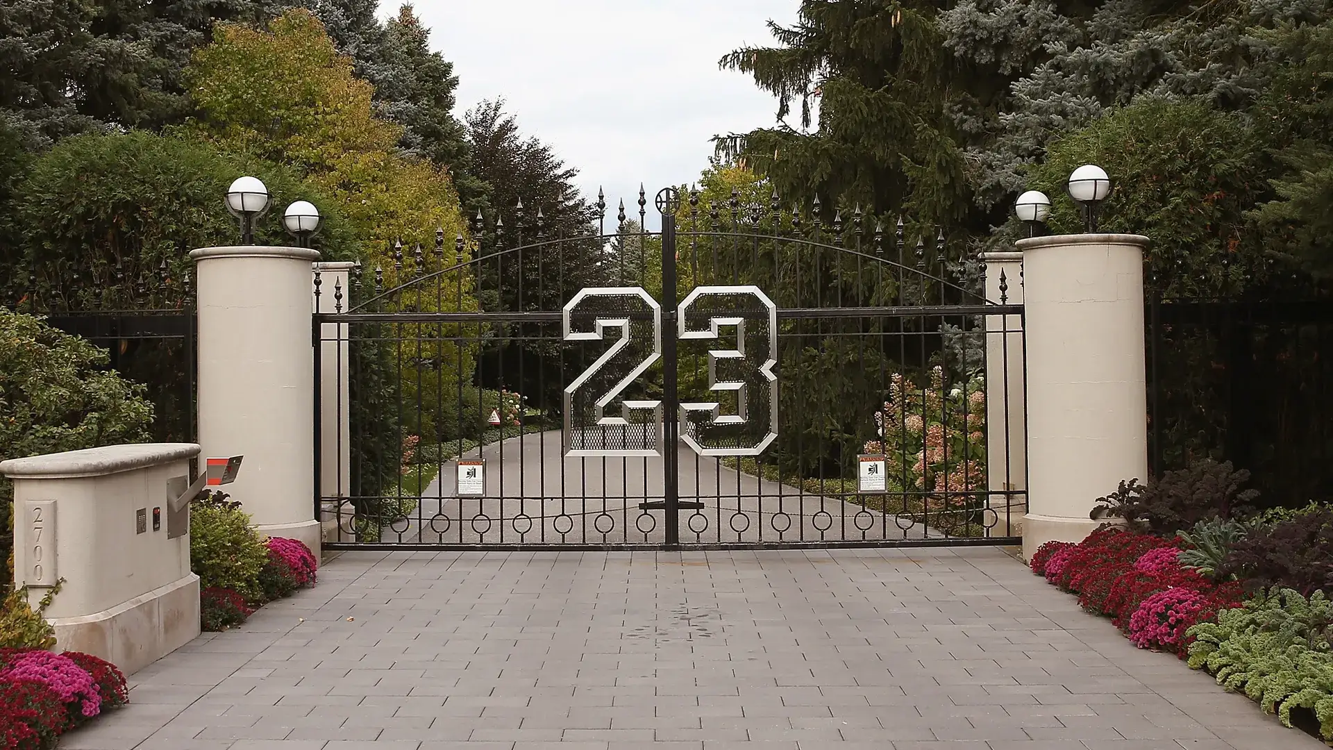 Michael Jordan mansion color black front steel gate with a number twenty three design with a bricks pathway.