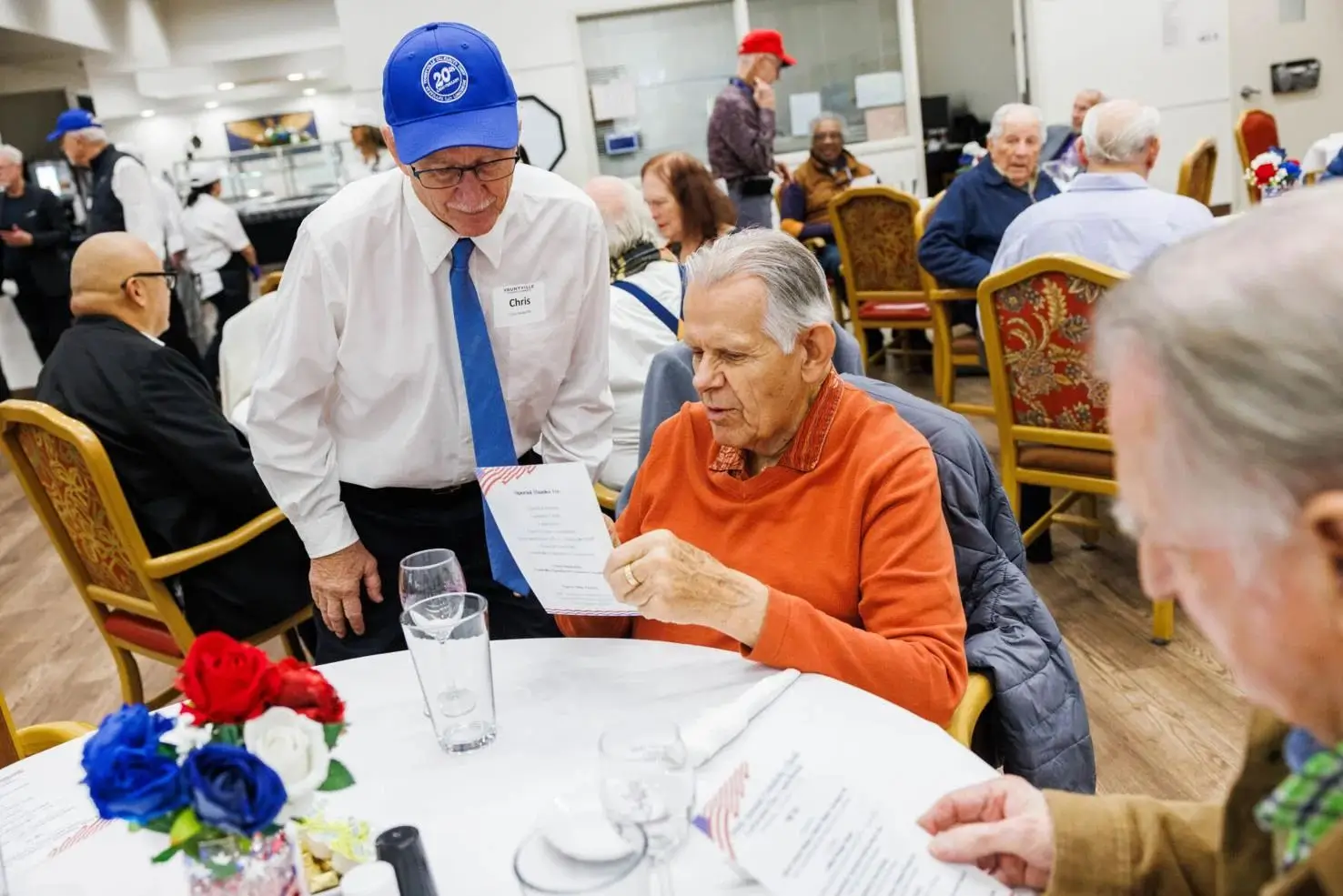 Volunteer Chris McAuliffe explains the menu to a guest during the Annual Celebrity Chefs luncheon for<br />
residents of the Yountville Veterans Home on Wednesday, November 6.<br />
Nick Otto/Register